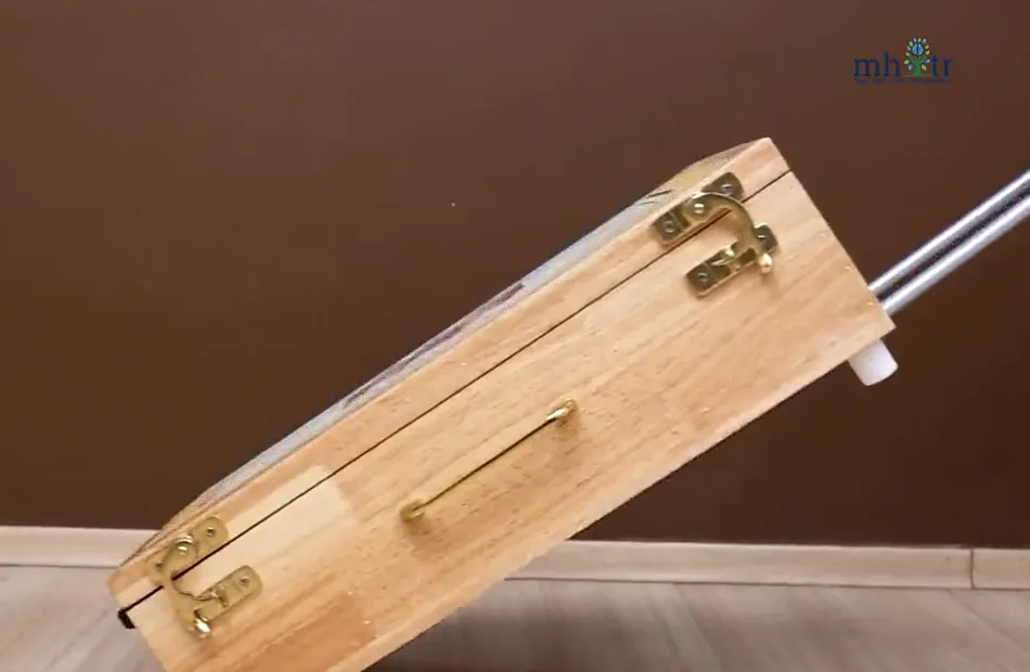 The closed wooden Vayofit Wellness Kit case being wheeled on its pull-out trolley handle