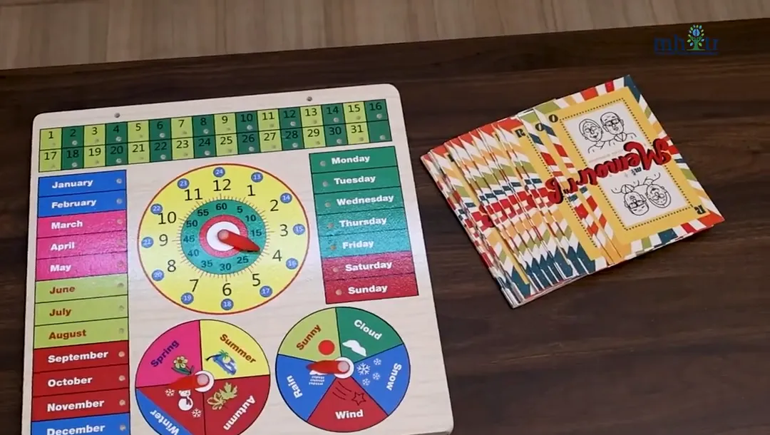 Wooden memory board with months, days, a clock dial and season and weather wheels beside a deck of Mi Memoir cards