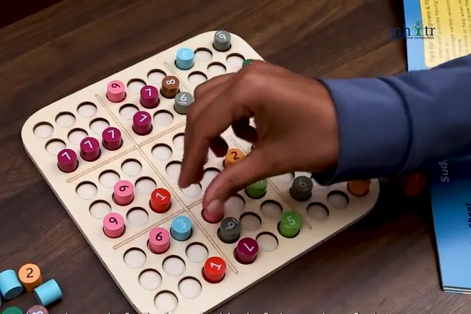 Hand placing a numbered peg on a wooden Sudoku board